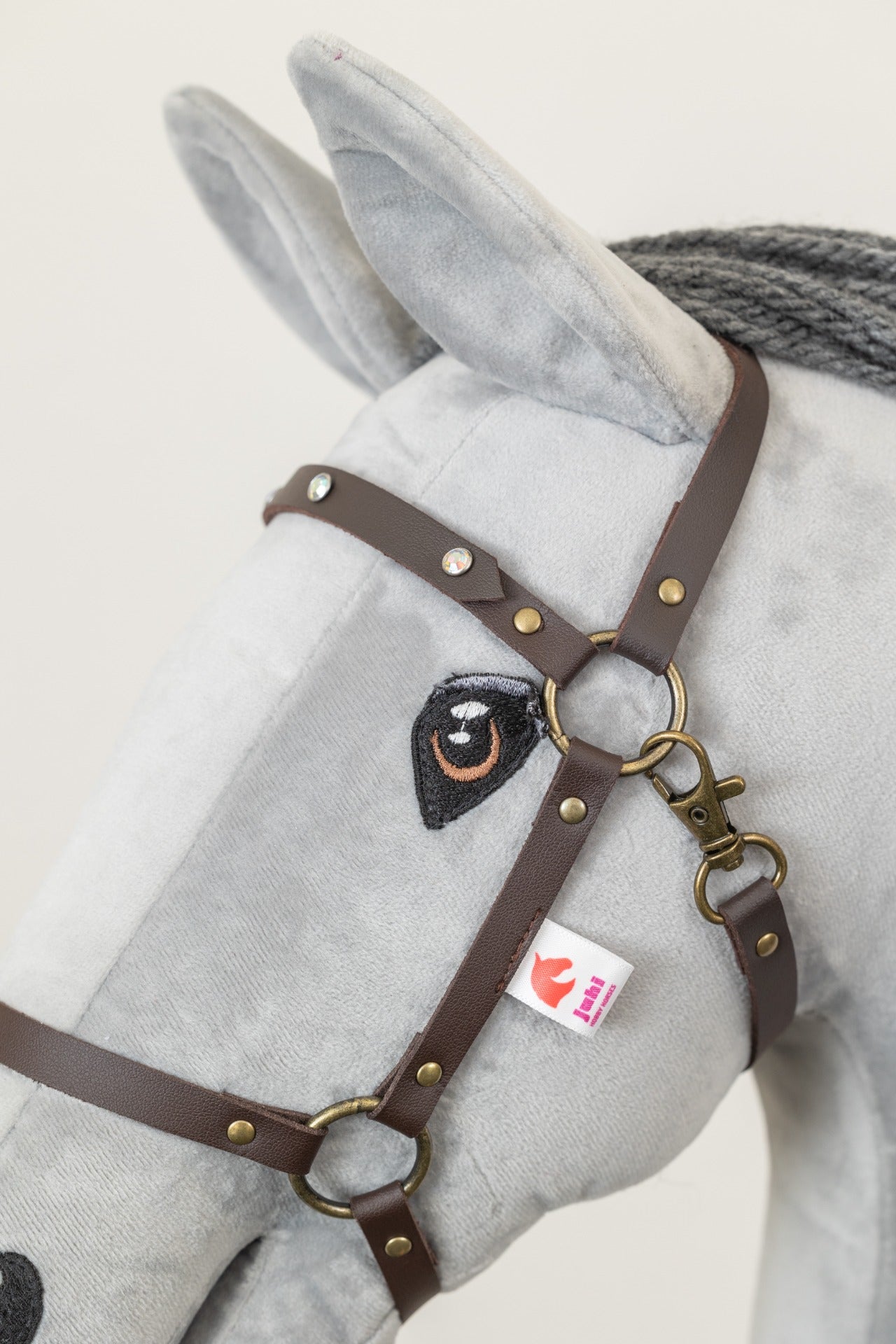 Hnědá ohlávka "Crystal" pro hobby horse, zdobená třpytivými kamínky se mosazným kováním, na koníkovi.